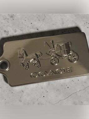 Coach, silver metal horse & carriage signature hang tag